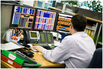 A Commodity Broker looking at his trading monitors