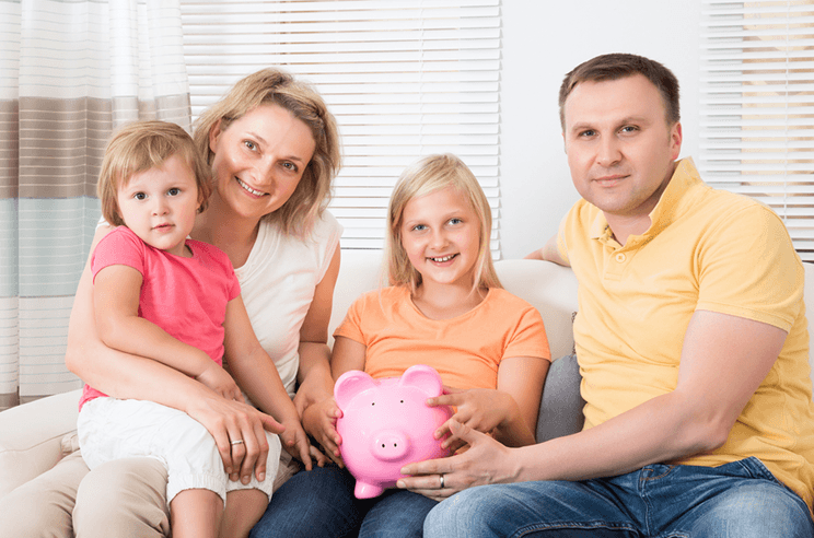 A family of two children seated together on a sofa with their eldest daughter holding a pink piggy bank with thoughts of looking for Effective College Financial Planning