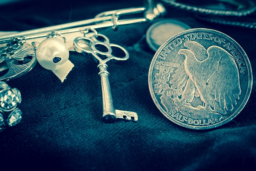 A key and half dollar coin sitting next to each other on dark material representing the key to approaching the right lender